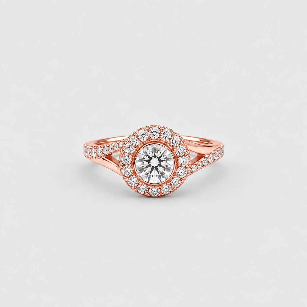 A rose gold halo ring with a round-cut center stone and surrounding pavé-set stones, photographed on a clean light gray background.