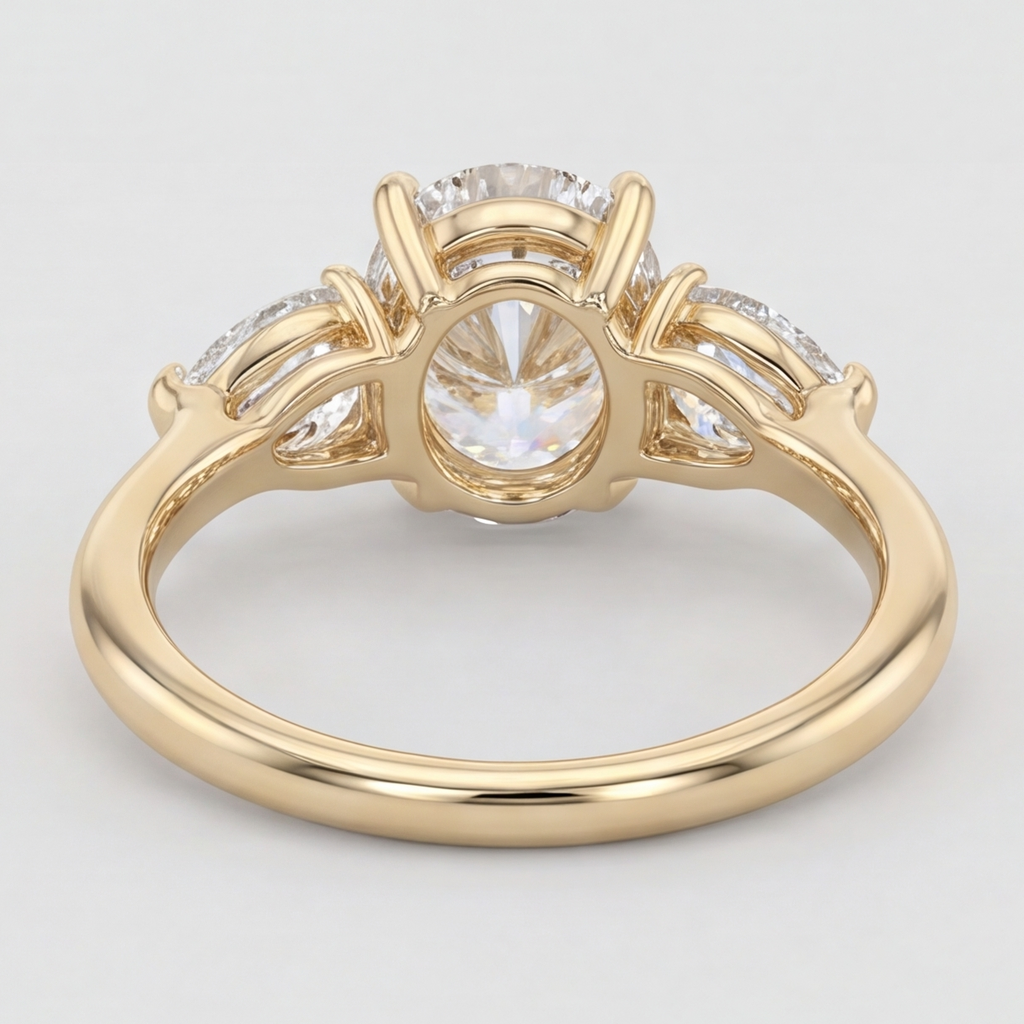 A yellow gold ring with a three-stone diamond setting, featuring a round center diamond and smaller diamonds on either side, shown on a light gray background.