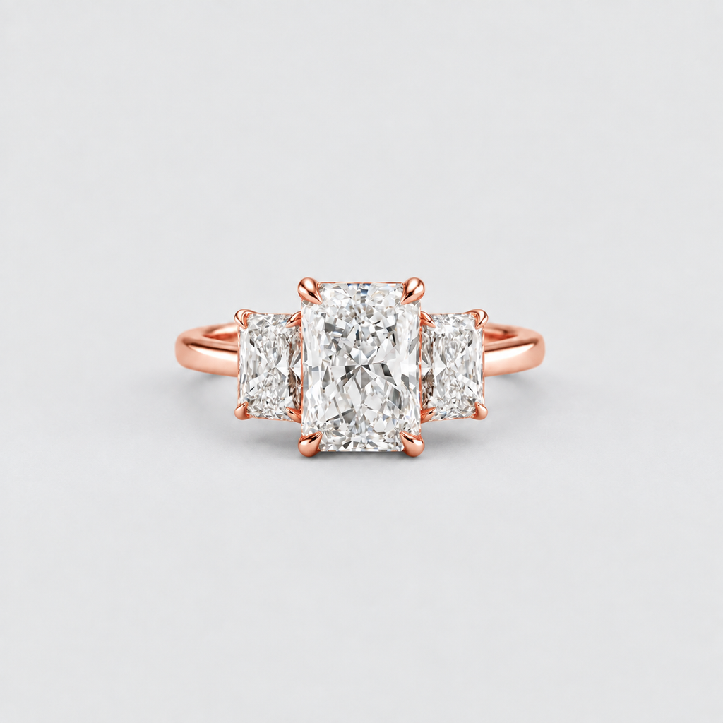 A rose gold three-stone ring featuring a large rectangular center diamond flanked by two smaller round diamonds, set against a clean light gray background.