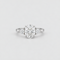 A silver diamond ring with a large oval center stone and three smaller round diamonds flanking it on a clean light gray background.