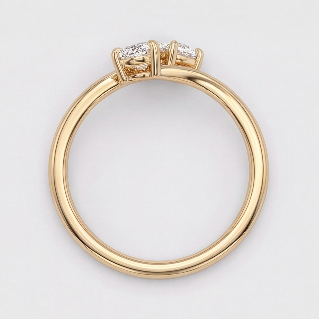 A yellow gold ring with three clear gemstones in a prong setting, shown from a top-down view on a light gray background.