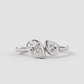 A silver ring featuring two pear-cut diamonds set in a split design, photographed on a clean light gray background.