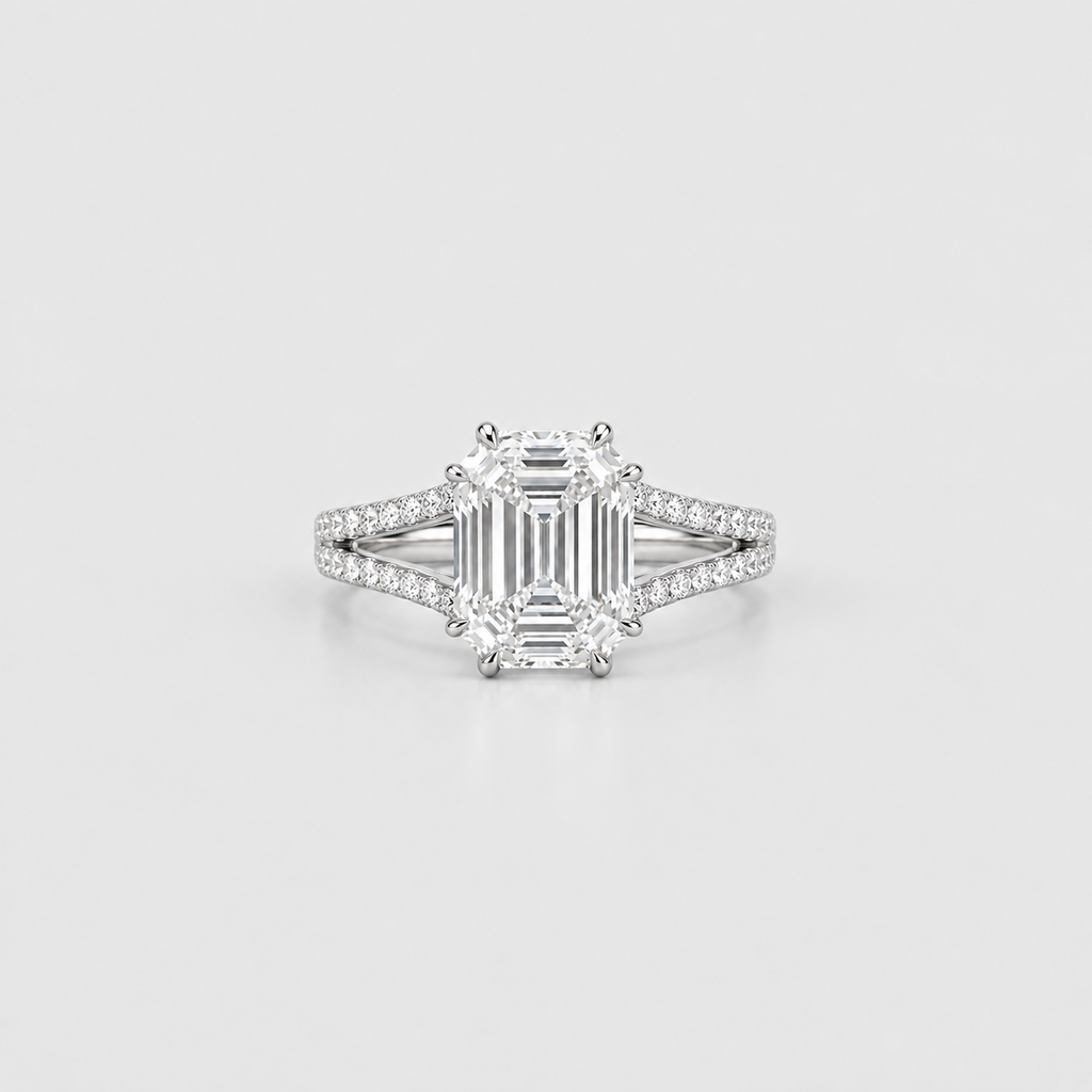An emerald-cut diamond engagement ring with a silver-toned diamond-accented band, centered on a light gray background.