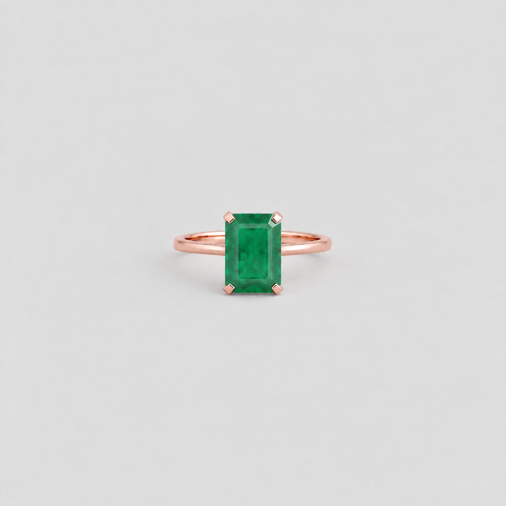 A rose gold ring featuring a rectangular emerald-cut green gemstone in a four-prong setting, centered on a light gray background.