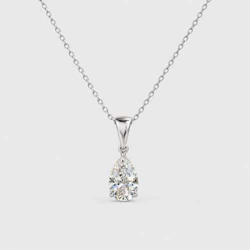 A pear-cut diamond pendant necklace on a delicate silver chain, set against a light gray background.