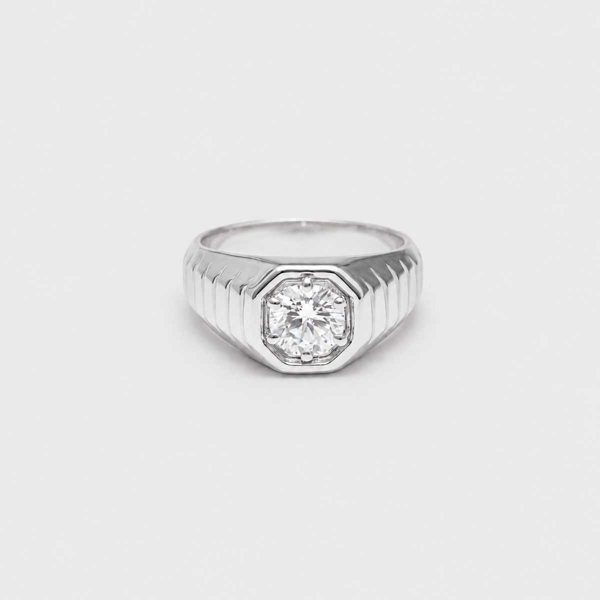 A silver-toned men's ring featuring an octagonal bezel-set round diamond on a ribbed shank, shown against a plain light gray background.