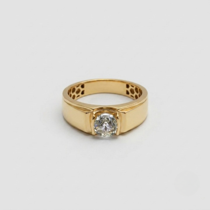 A yellow gold ring with a single round-cut clear gemstone in a bezel setting, displayed on a clean light gray background.
