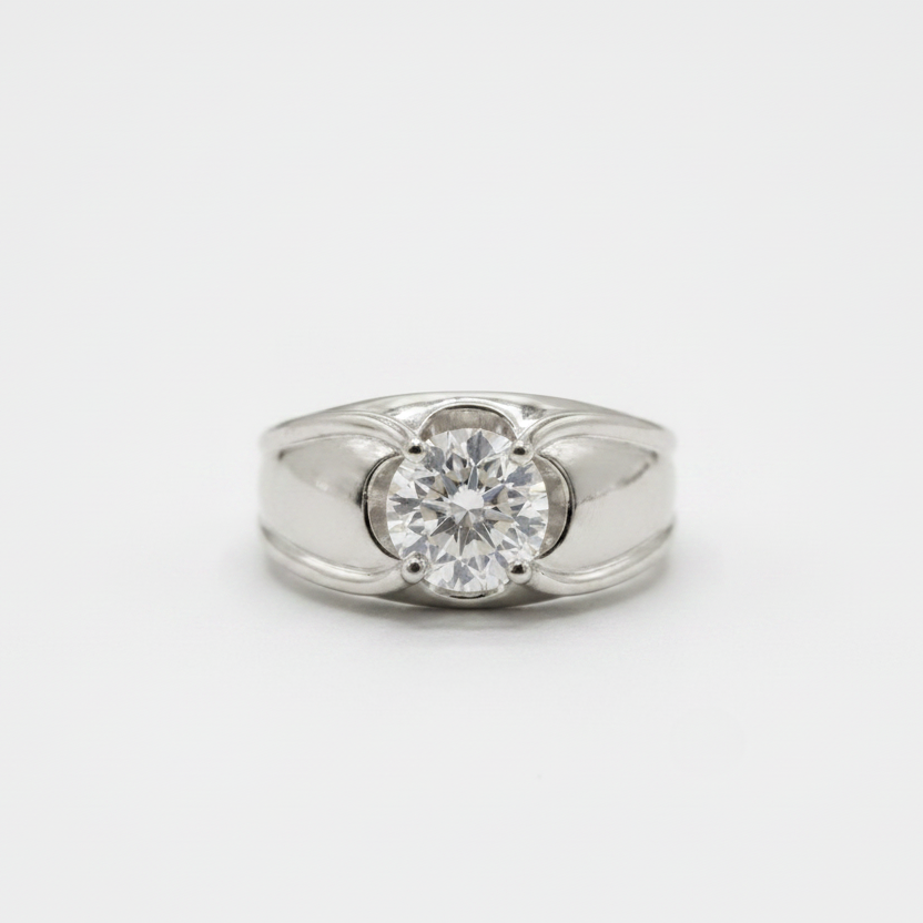 A silver ring featuring a round-cut clear gemstone in a four-prong setting, with decorative curved metalwork on either side of the stone, shown on a light gray background.