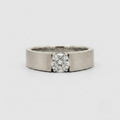 A minimalist solitaire ring featuring a round brilliant-cut diamond set in a brushed silver-toned metal band, photographed on a clean, light gray background.
