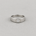 A silver ring with a square-cut diamond set in a decorative bezel, shown on a textured gray background.