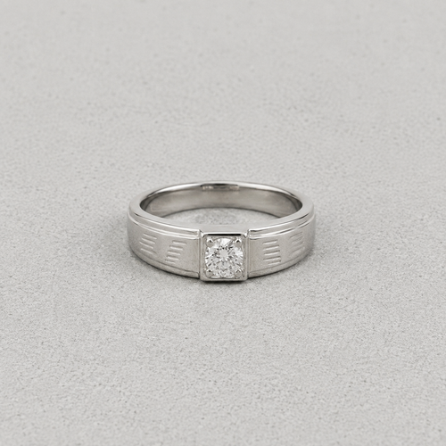 A silver ring with a square-cut diamond set in a decorative bezel, shown on a textured gray background.