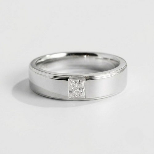 A polished silver band ring featuring a single princess-cut diamond solitaire setting, photographed on a clean light gray background.