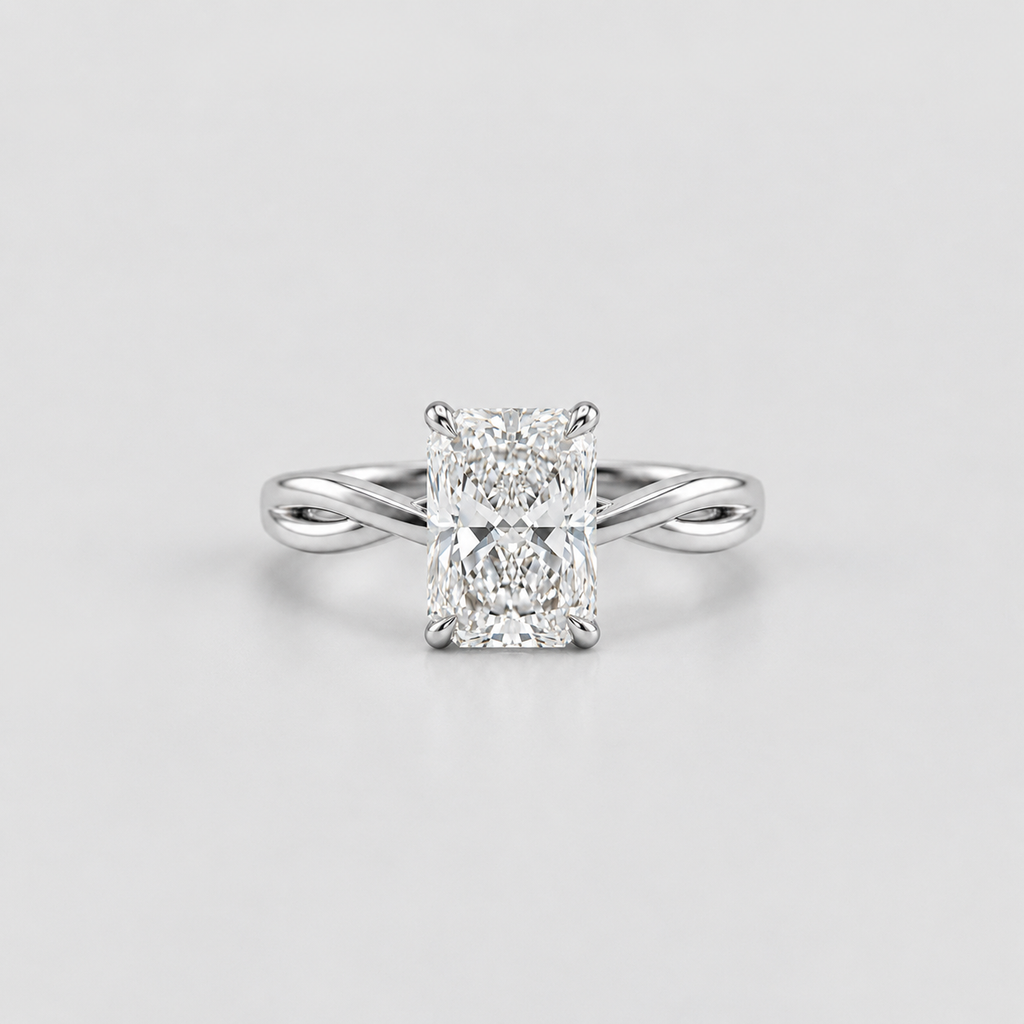 An radiant cut diamond engagement ring with a silver-colored split-shank band, centered on a light gray background.
