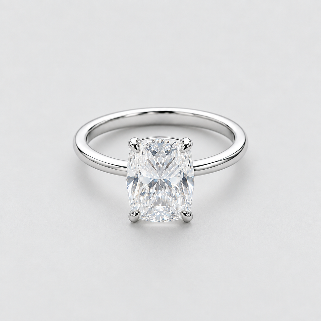 A classic solitaire engagement ring featuring a rectangular radiant-cut diamond set in a polished white gold or platinum band, photographed on a clean, light gray background.