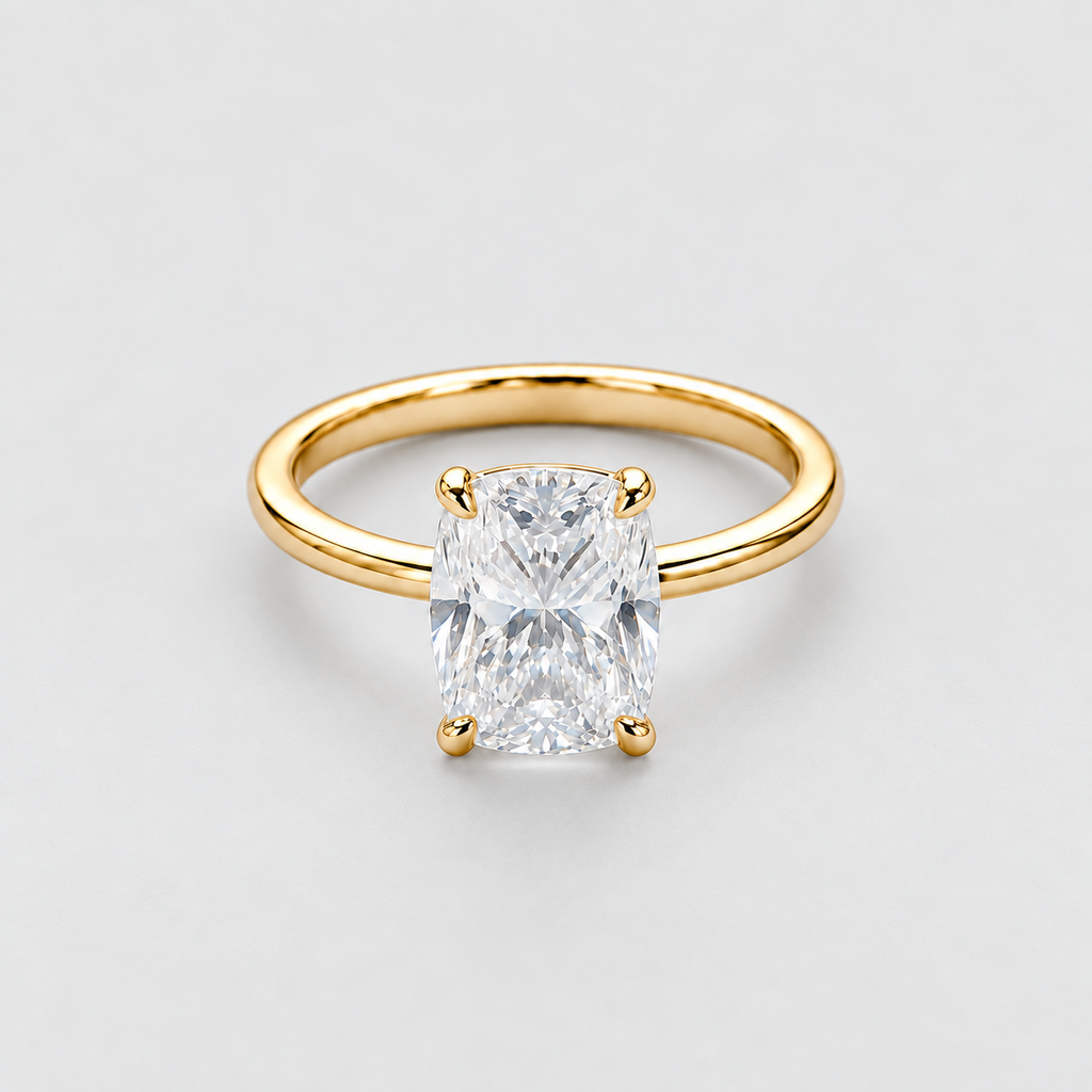 A yellow gold solitaire ring featuring a large rectangular radiant-cut clear gemstone in a four-prong setting, photographed on a clean light gray background.