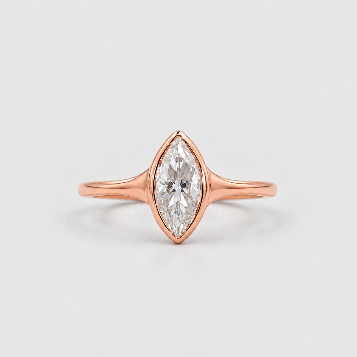 A rose gold ring with a marquise-cut clear gemstone, shown on a clean light gray background.