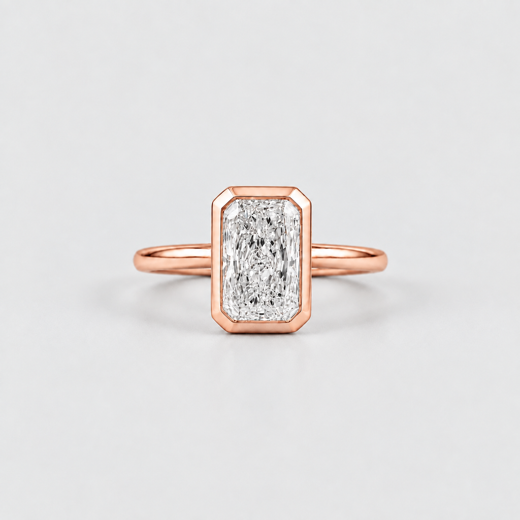 A rose gold ring featuring a rectangular baguette-cut diamond in a bezel setting, shown on a clean light gray background.