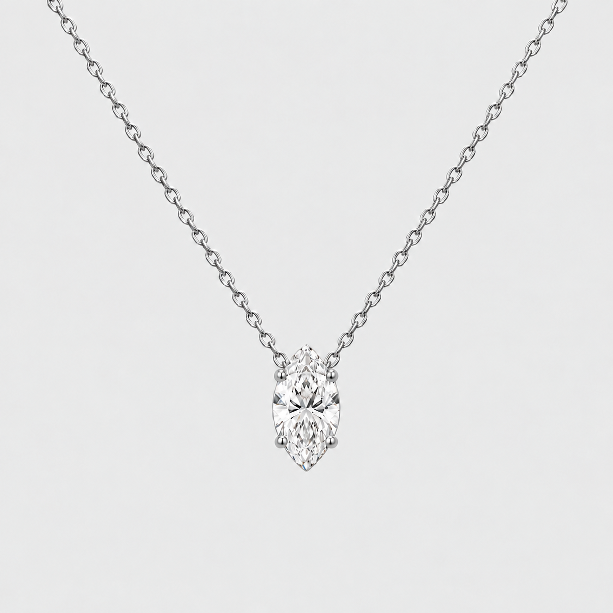 A silver-tone chain necklace with a single marquise-cut diamond pendant, shown against a light gray background.