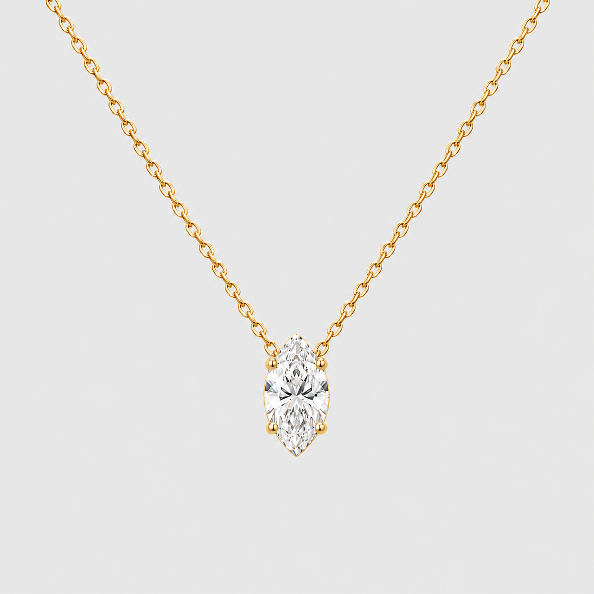 A yellow gold necklace with a marquise-cut diamond pendant, shown against a light gray background.