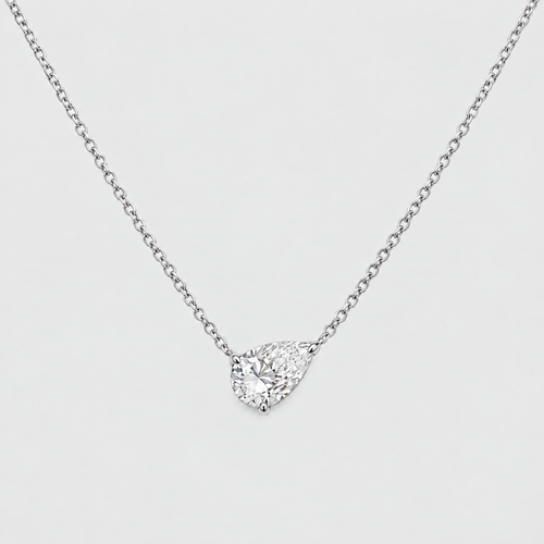 A silver-toned chain necklace with a pear-cut clear gemstone pendant in a prong setting, shown on a light gray background.