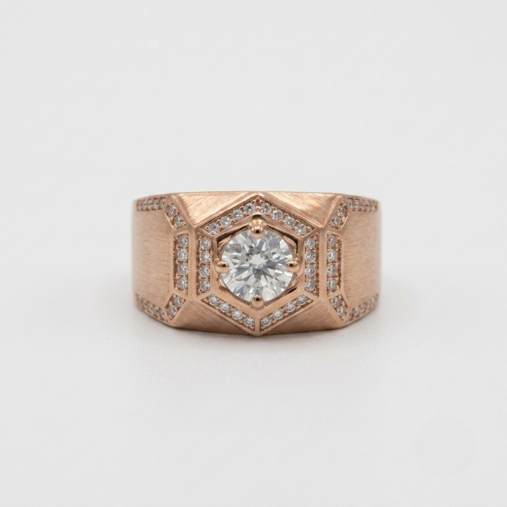 A geometric rose gold ring featuring a central round-cut clear gemstone surrounded by a halo of small pavé-set diamonds, set against a clean white background.