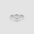 A heart-shaped diamond engagement ring with a silver-colored band set with small pavé diamonds, centered on a light gray background.