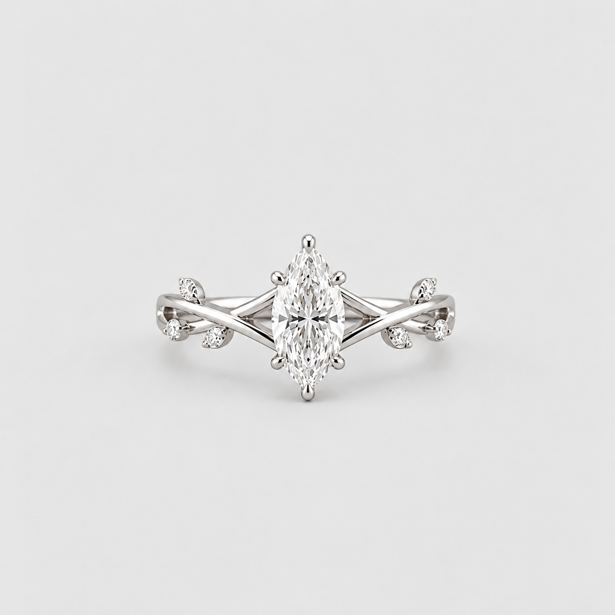 An elegant silver-tone ring featuring a marquise-cut center stone in a six-prong setting, flanked by delicate twisted band details and small accent stones, shown on a light gray background.