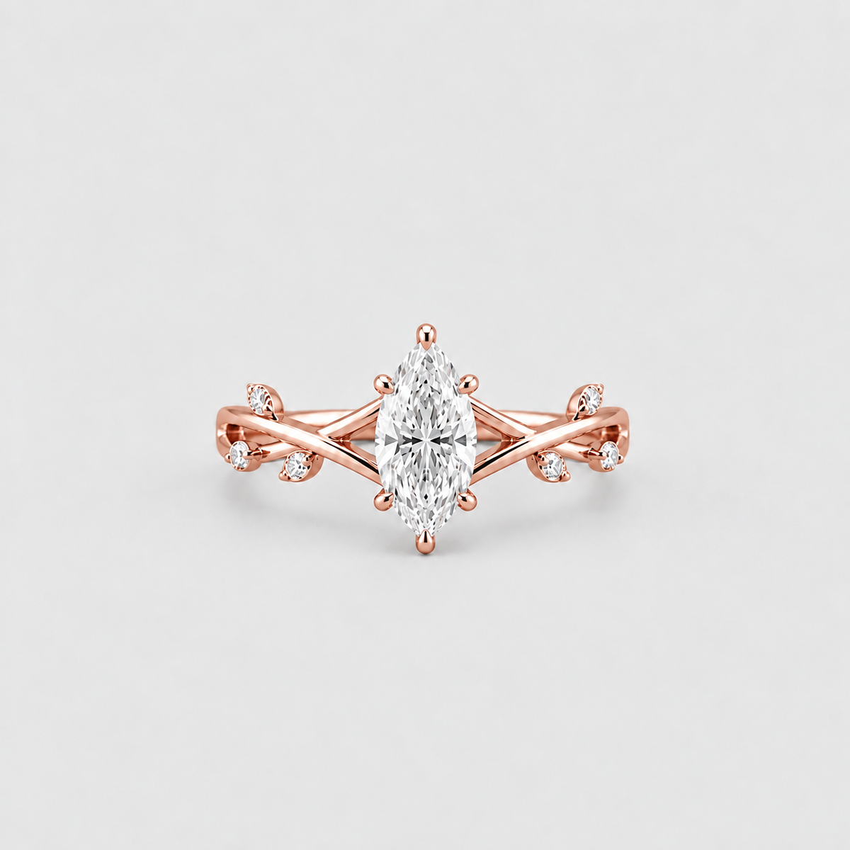 Rose gold ring with a marquise-cut center stone and small accent stones on a clean light gray background.