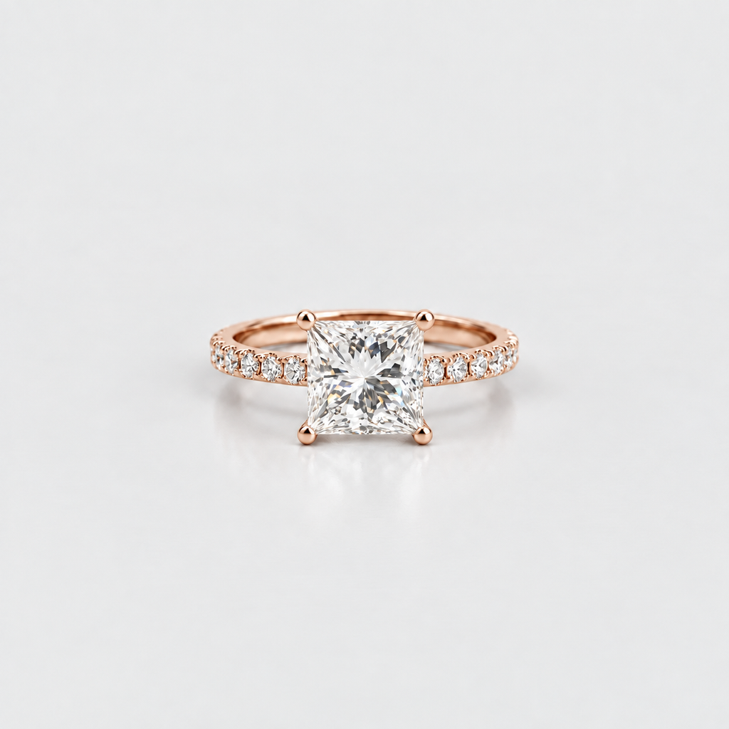 A rose gold engagement ring featuring a princess-cut diamond center stone and pavé diamonds along the band, set against a clean white background.