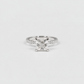 A silver engagement ring featuring a princess-cut diamond center stone and a pavé-set band, photographed on a clean white background.