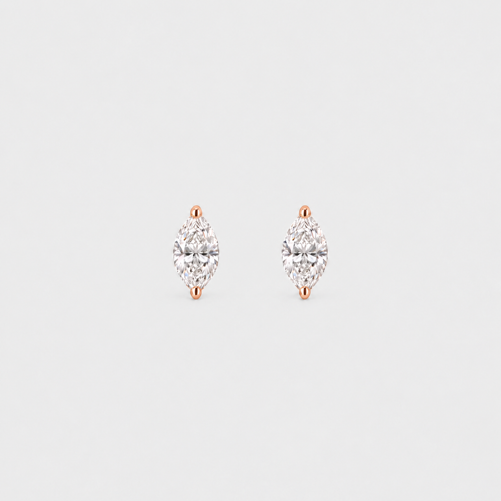 A pair of rose gold stud earrings with marquise-cut clear gemstones, set against a solid light gray background.
