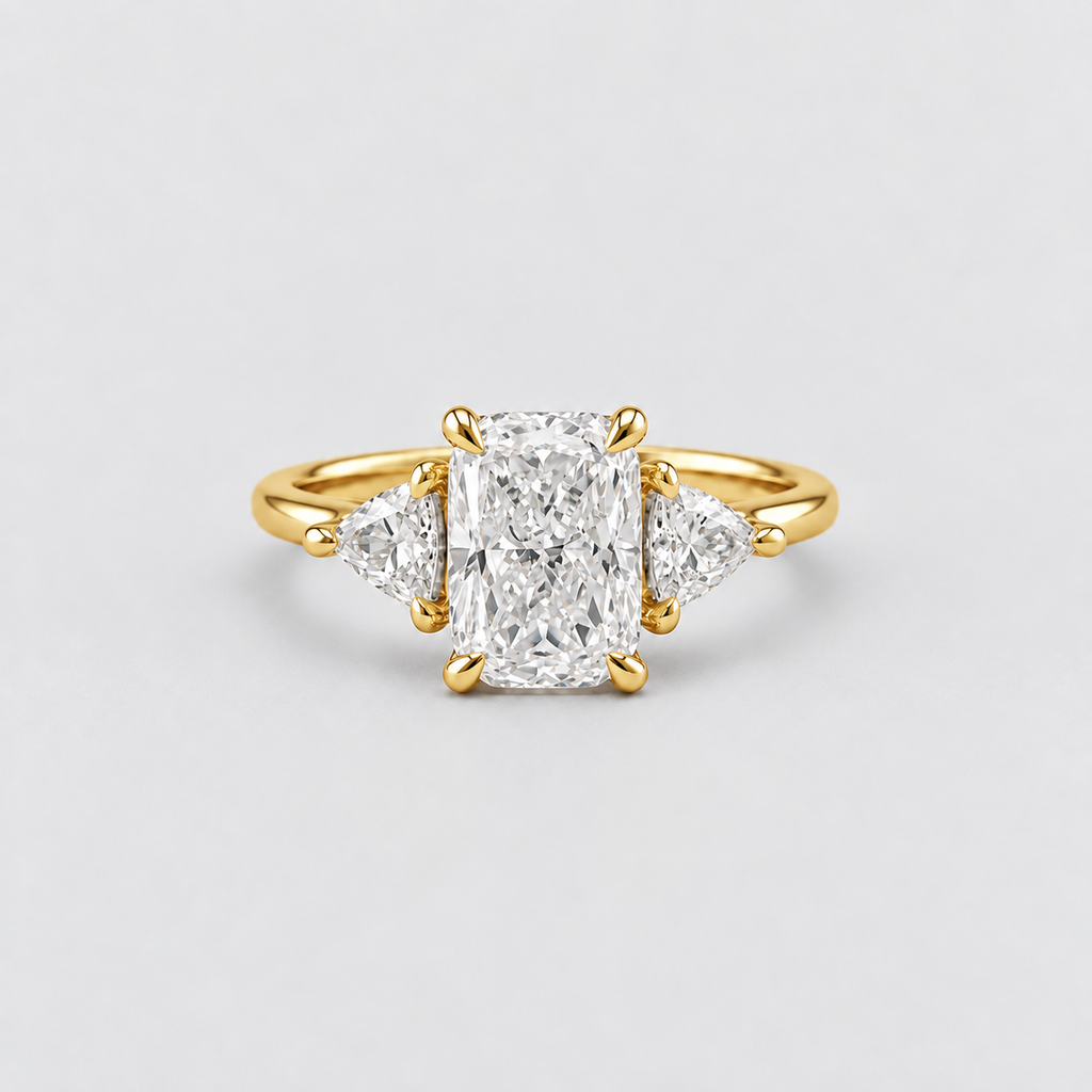 A yellow gold three-stone ring featuring a central rectangular radiant-cut diamond flanked by two smaller round-cut diamonds, set against a clean light gray background.