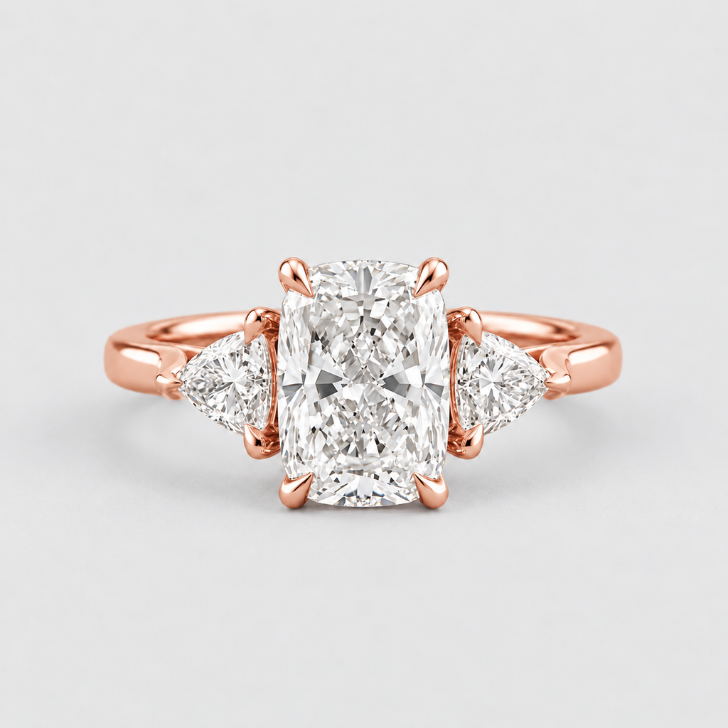 A rose gold engagement ring featuring a large rectangular radiant-cut center diamond flanked by two smaller pear-cut side diamonds, set on a polished band against a light gray background.