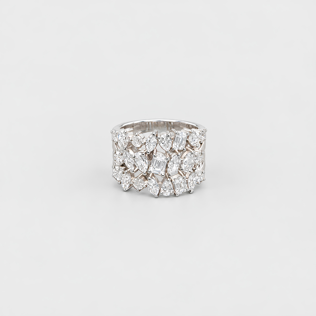 A wide silver ring featuring a dense cluster of clear gemstones in marquise and round shapes, photographed on a clean light gray background.