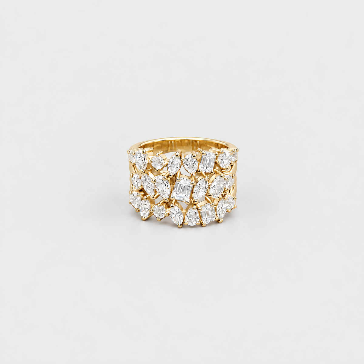A wide gold band ring set with multiple rows of marquise-cut clear gemstones, photographed on a clean light gray background.