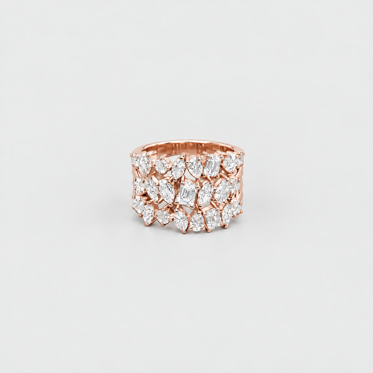 A rose gold ring featuring multiple rows of marquise-cut and oval diamonds, photographed against a clean, light gray background.