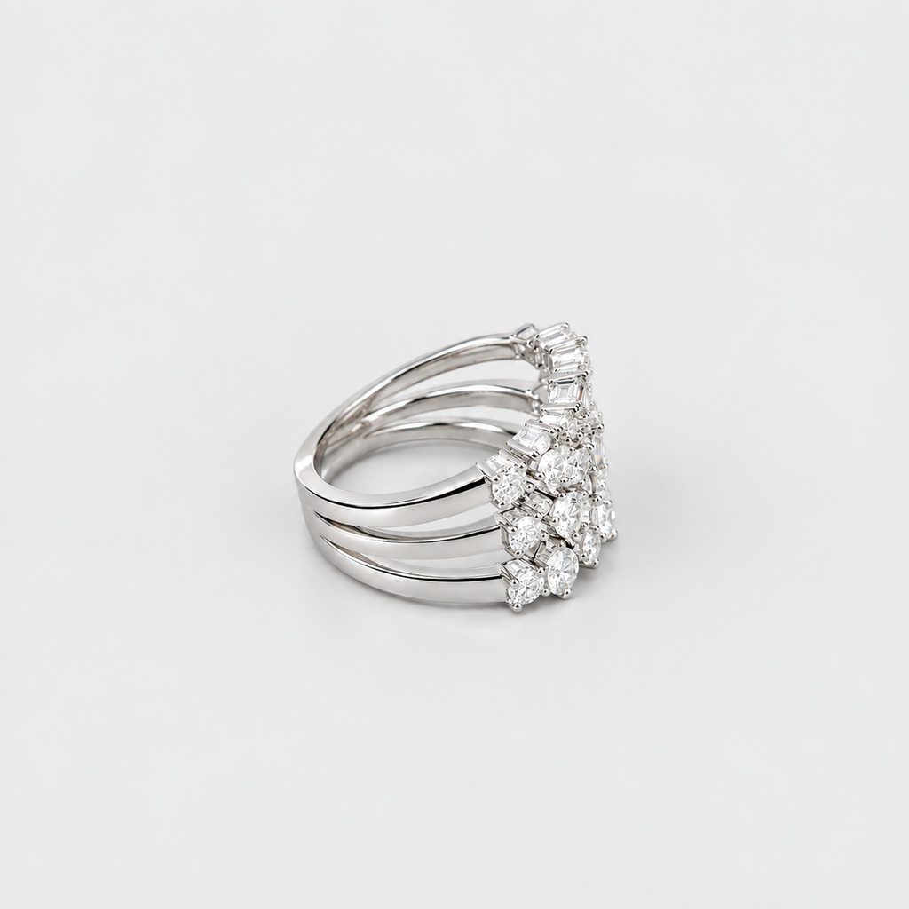 A silver-toned multi-band ring featuring a floral cluster of clear gemstones on the front, photographed on a clean light gray background.