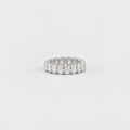 A silver diamond eternity ring with a continuous row of round-cut diamonds set in a polished silver band, photographed on a seamless light gray background.