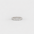 A silver-tone eternity ring set with round brilliant-cut diamonds, photographed on a seamless light gray background.