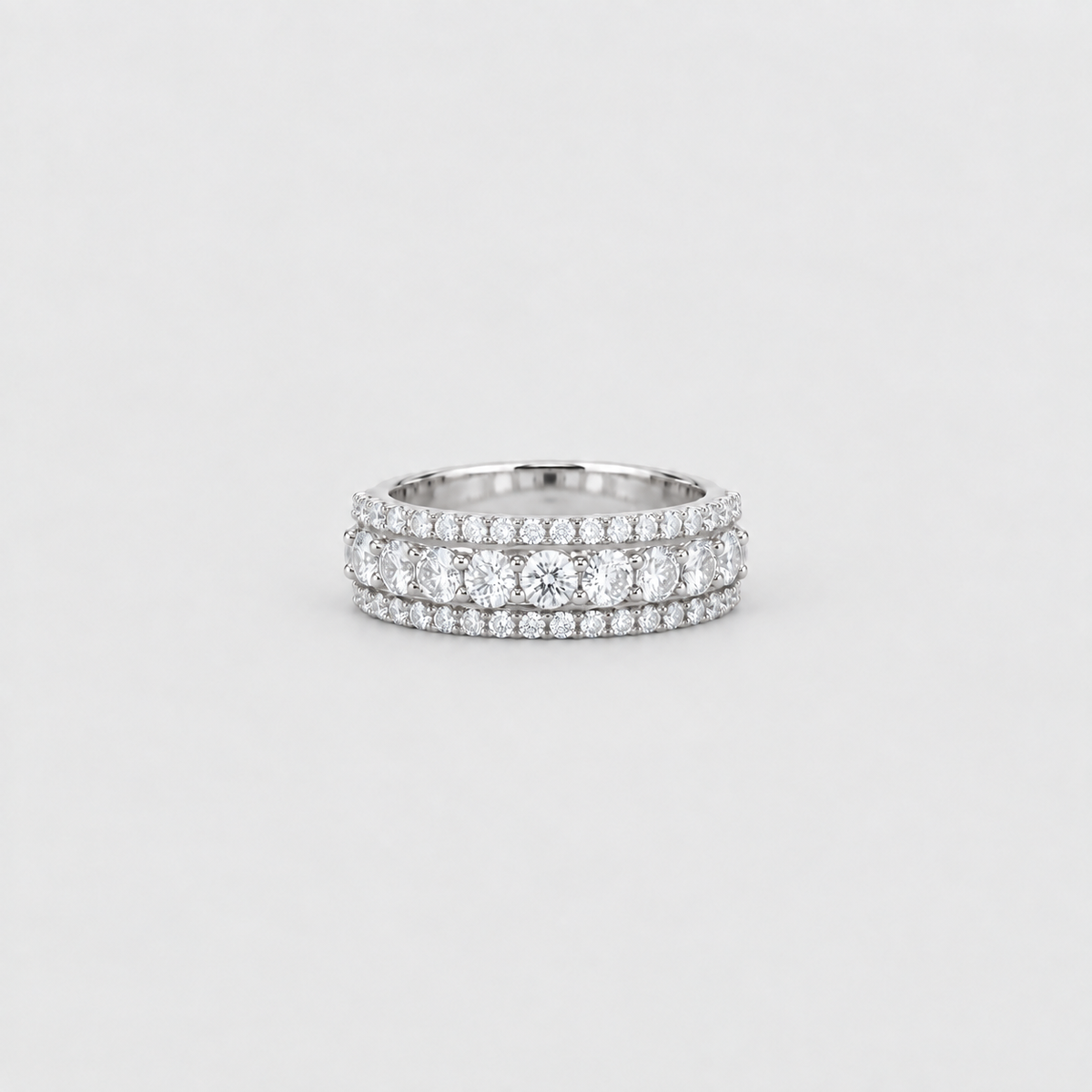 A silver double-row diamond eternity ring with a center round diamond, set against a clean light gray background.
