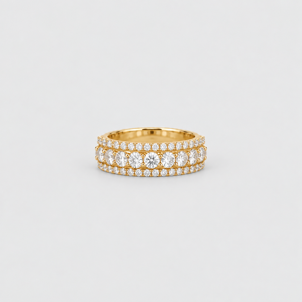 A yellow gold eternity ring featuring three rows of round brilliant-cut and cushion-cut diamonds, photographed on a clean, light gray background.