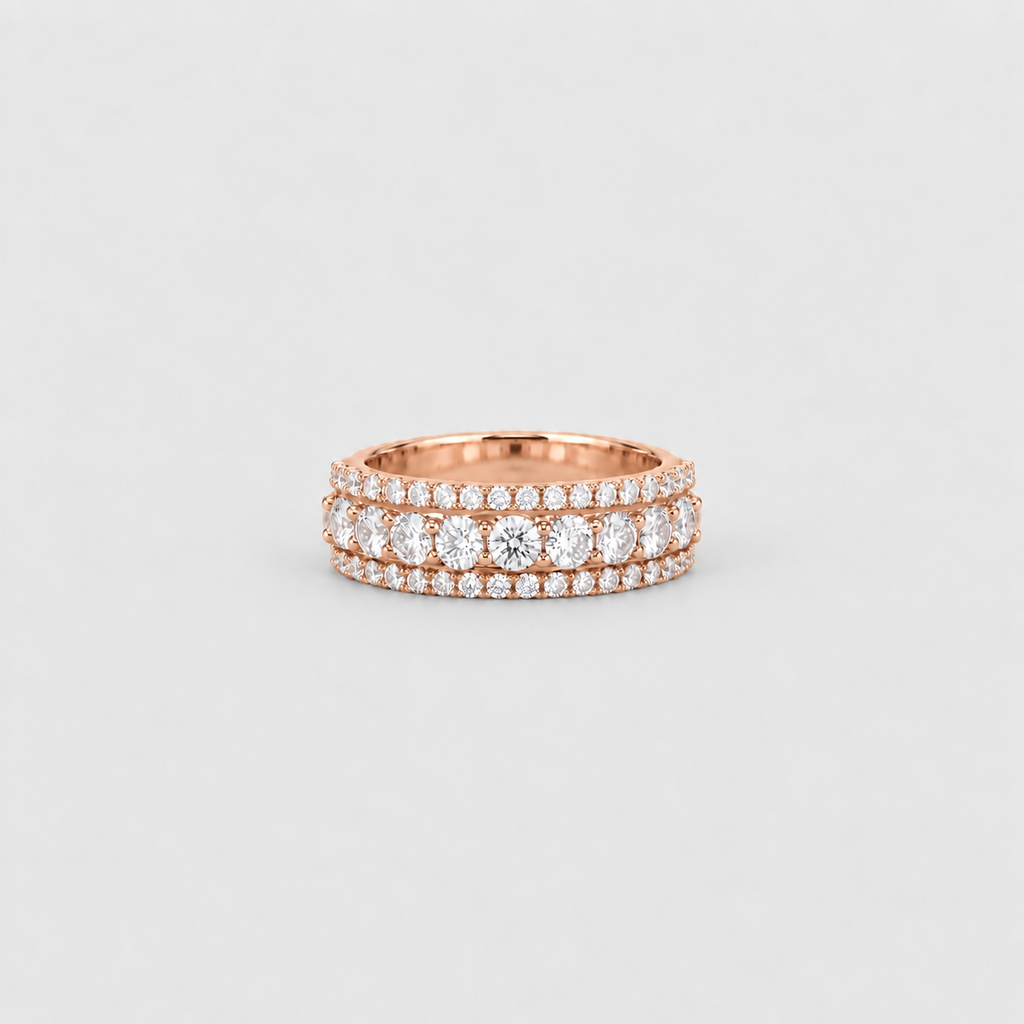 A rose gold eternity ring featuring three rows of round-cut clear gemstones, set against a clean light gray background.