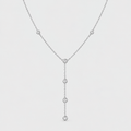 A delicate silver Y-necklace featuring five small, round clear gemstones set along the chain, suspended against a light gray background.