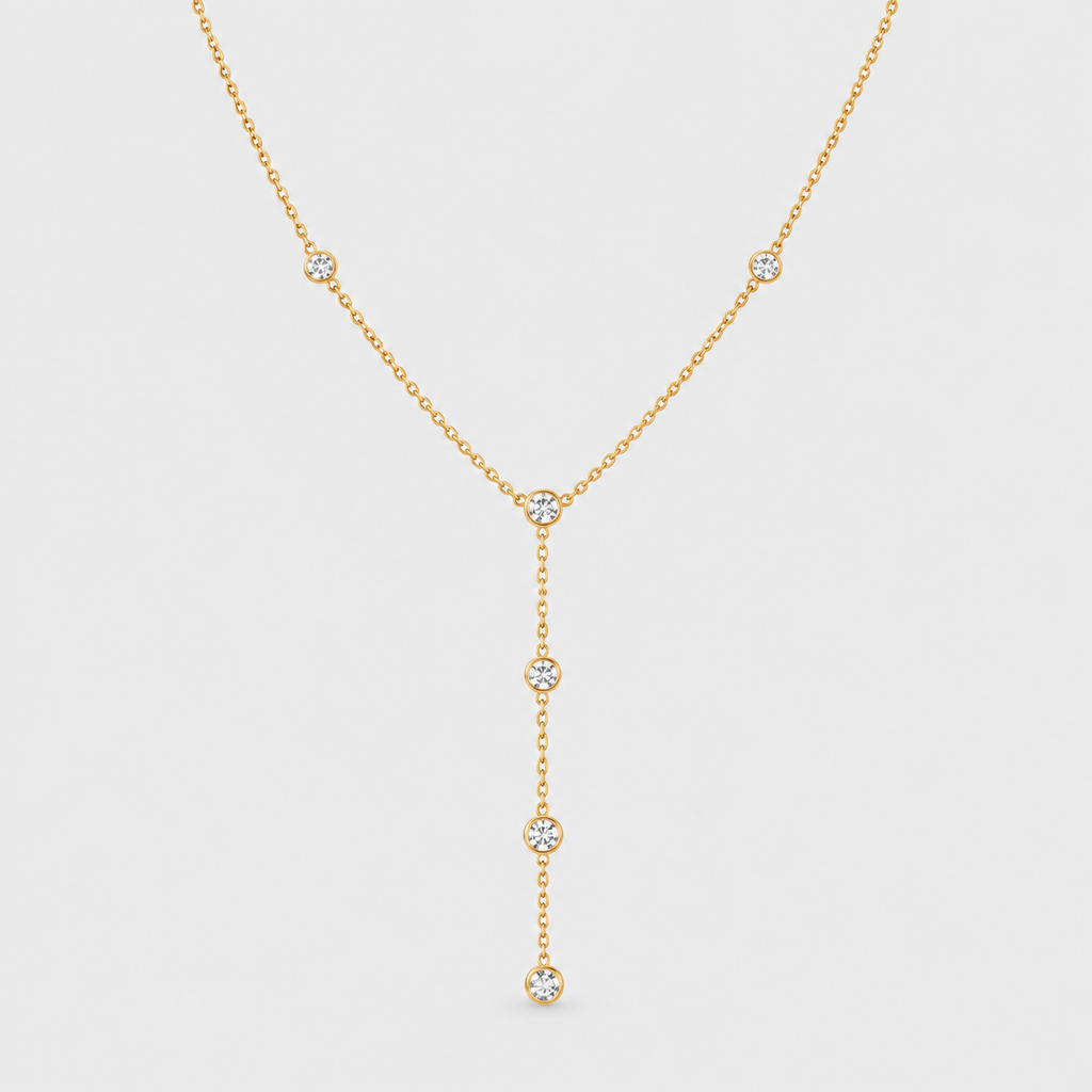 A delicate gold Y-necklace featuring five small round-cut clear gemstones set along the chain and hanging drape, displayed against a light gray background.