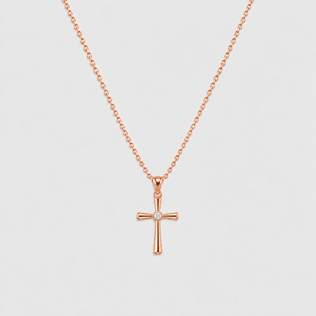 A rose gold cross pendant necklace with a small clear gemstone at the center, suspended from a delicate matching chain against a light gray background.