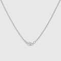 A delicate silver chain necklace featuring a small central cluster of clear gemstones, photographed against a clean, light gray background.