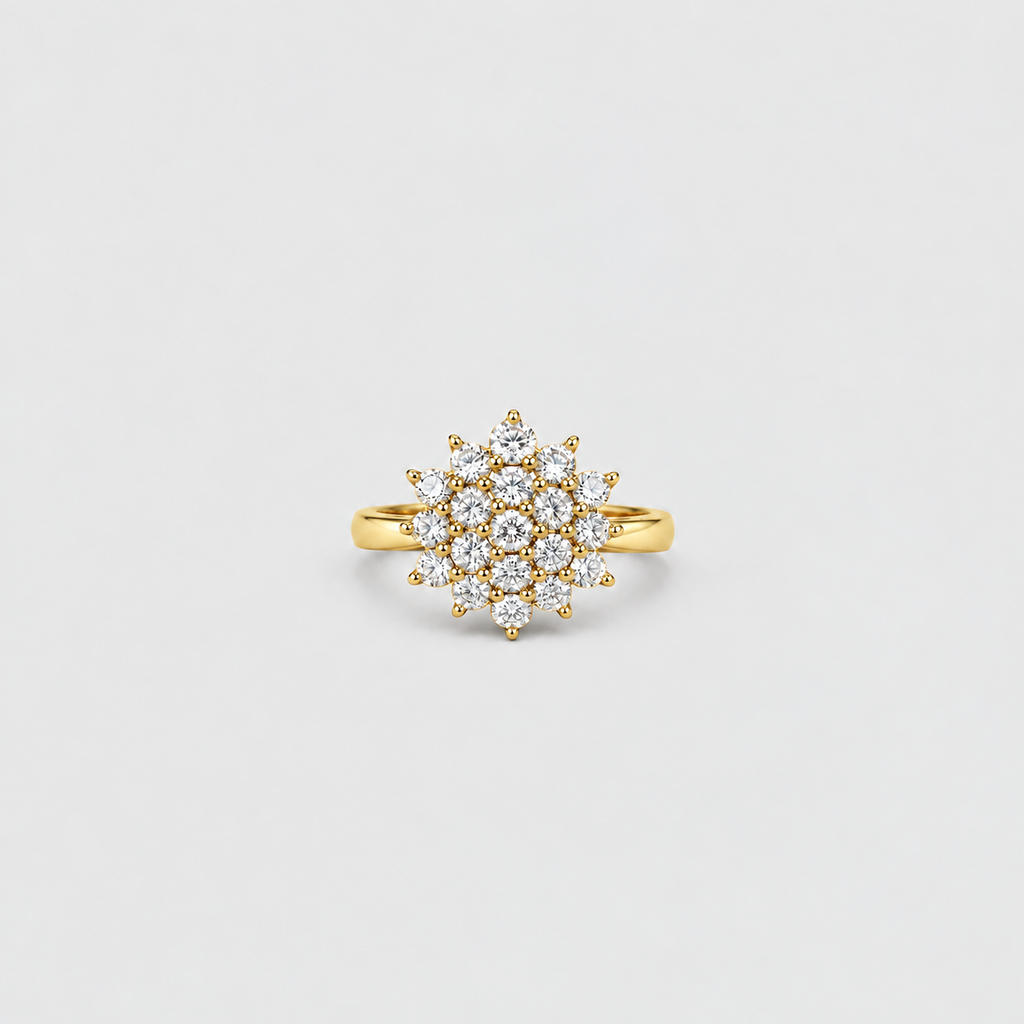 A yellow gold ring featuring a circular cluster of small clear gemstones, photographed against a clean, light gray background.