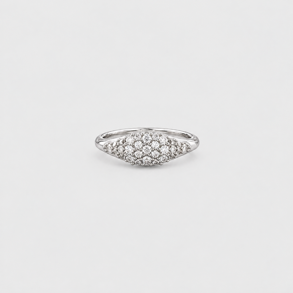A silver pavé ring with a marquise-shaped cluster of small clear stones, photographed on a light gray background.