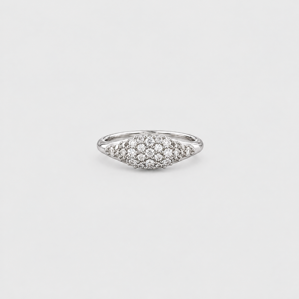 A silver pavé ring with a marquise-shaped cluster of small clear stones, photographed on a light gray background.