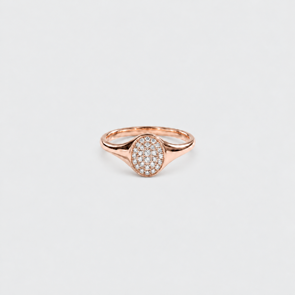 A rose gold ring featuring an oval pavé diamond setting on a clean, light gray background.